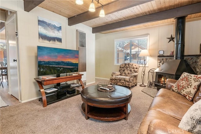 carpeted living room featuring wood ceiling, beam ceiling, and a wood stove