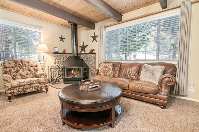 living area featuring beamed ceiling, wood ceiling, a healthy amount of sunlight, and carpet floors