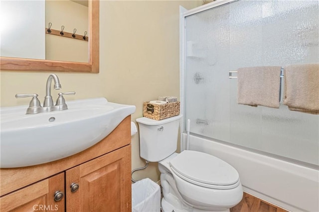 full bathroom with vanity, combined bath / shower with glass door, and toilet