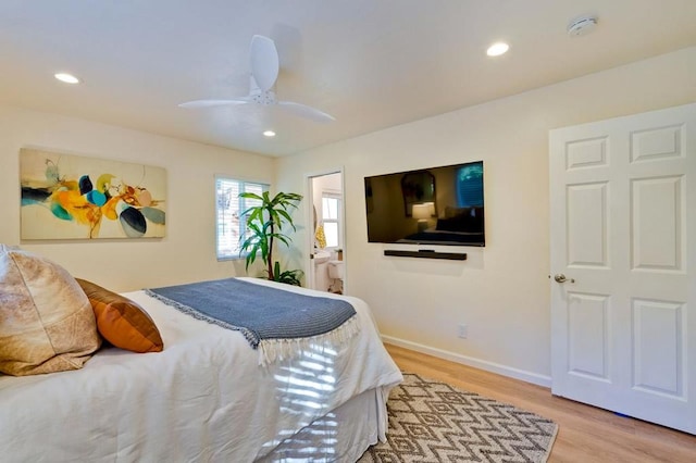 bedroom with ceiling fan, ensuite bathroom, and light hardwood / wood-style floors