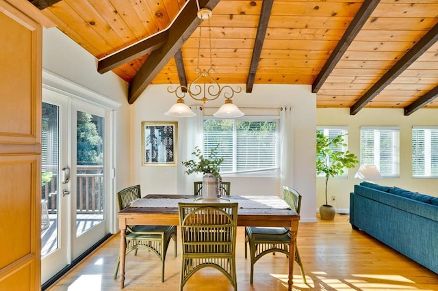 dining space featuring vaulted ceiling with beams, light wood-type flooring, and french doors