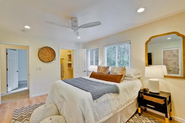 bedroom with a spacious closet, ceiling fan, and light wood-type flooring