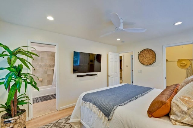 bedroom featuring ceiling fan, light hardwood / wood-style floors, and ensuite bath