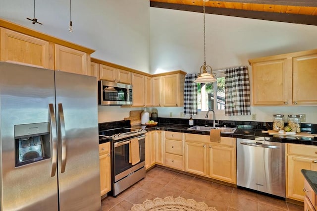 kitchen with stainless steel appliances, hanging light fixtures, sink, and light brown cabinetry