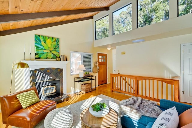 living room featuring lofted ceiling with beams, a tiled fireplace, hardwood / wood-style floors, and wooden ceiling