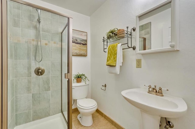 bathroom with sink, tile patterned floors, toilet, and a shower with door