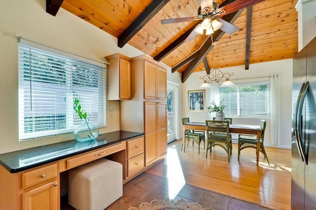 kitchen featuring pendant lighting, stainless steel fridge, vaulted ceiling with beams, built in desk, and light brown cabinetry