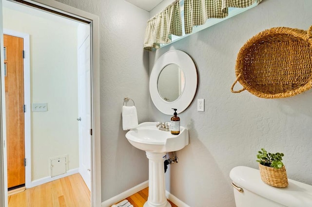 bathroom with toilet and hardwood / wood-style floors