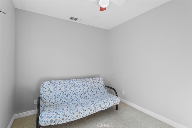 sitting room with ceiling fan and carpet flooring