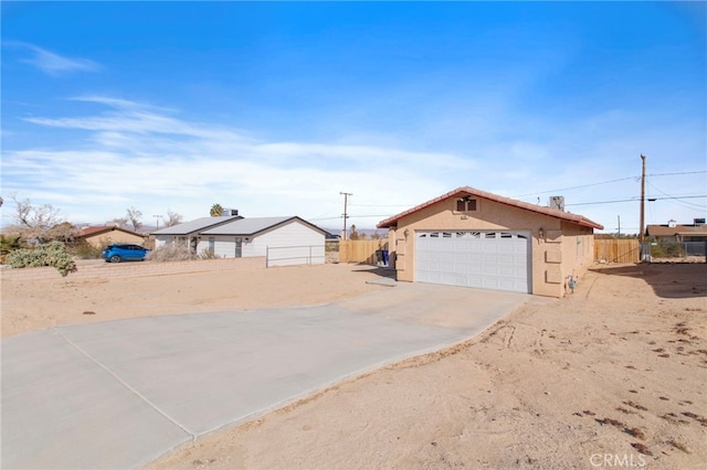 ranch-style home with a garage and an outbuilding