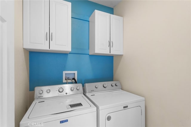 washroom with washing machine and dryer and cabinets