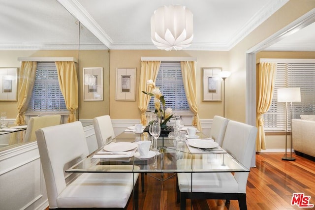 dining space with wood-type flooring and ornamental molding