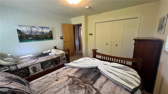 bedroom with a closet and wallpapered walls