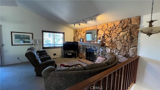 living room featuring vaulted ceiling, rail lighting, and a fireplace