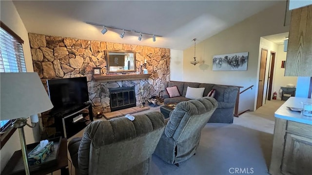 living room with carpet floors, lofted ceiling, a fireplace, and track lighting