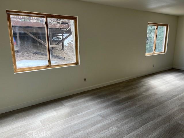 unfurnished room with wood finished floors and baseboards