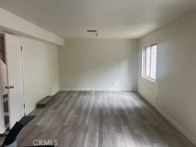 empty room featuring wood finished floors and baseboards