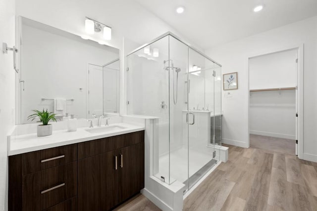 bathroom with vanity, hardwood / wood-style flooring, and a shower with shower door