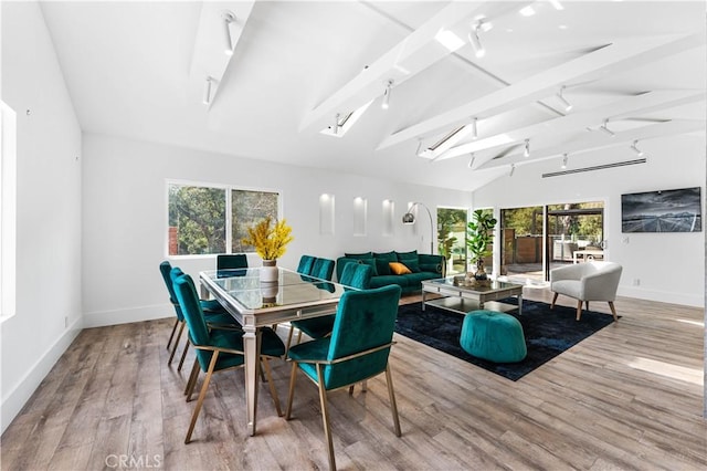 sunroom / solarium featuring lofted ceiling with beams and track lighting