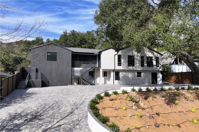 view of front facade with decorative driveway, a patio area, fence, and stairway