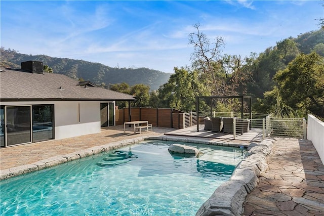 view of swimming pool featuring fence, a mountain view, a fenced in pool, and a patio