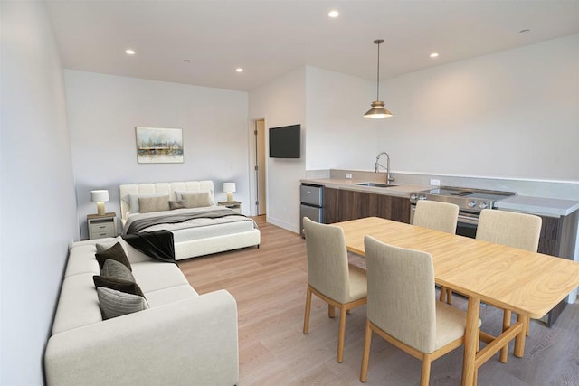 dining space with sink and light wood-type flooring