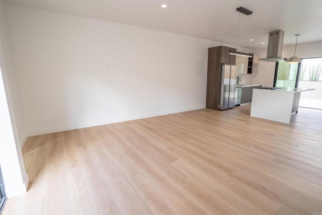 unfurnished living room featuring sink and light wood-type flooring