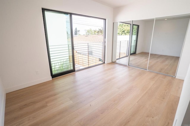 unfurnished bedroom featuring light hardwood / wood-style flooring and access to outside