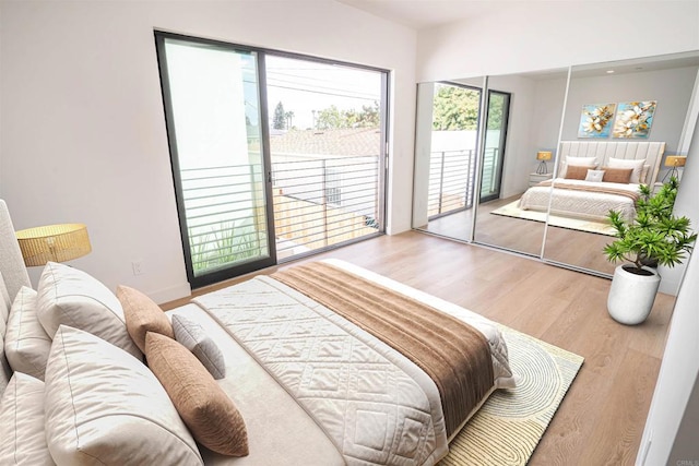 bedroom with hardwood / wood-style floors and access to outside