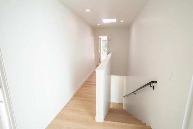 staircase with wood-type flooring and a skylight