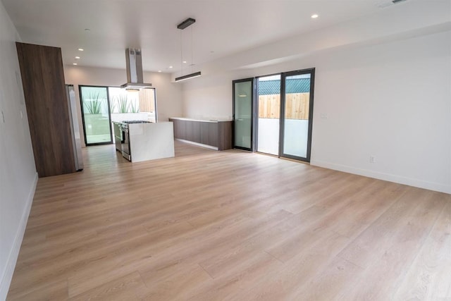 unfurnished living room with plenty of natural light and light hardwood / wood-style flooring