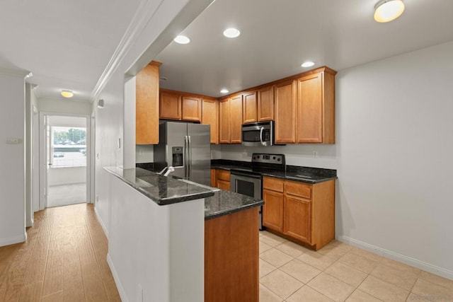 kitchen with sink, dark stone counters, ornamental molding, kitchen peninsula, and stainless steel appliances