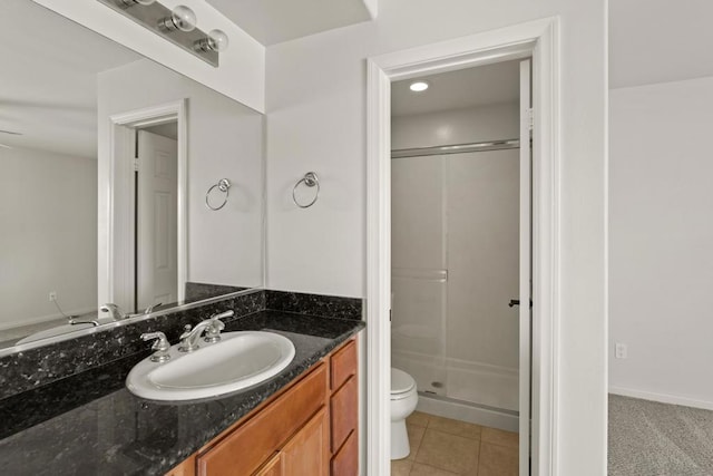 bathroom featuring tile patterned flooring, vanity, toilet, and walk in shower