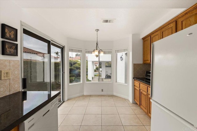 kitchen with pendant lighting, white appliances, tasteful backsplash, and light tile patterned floors