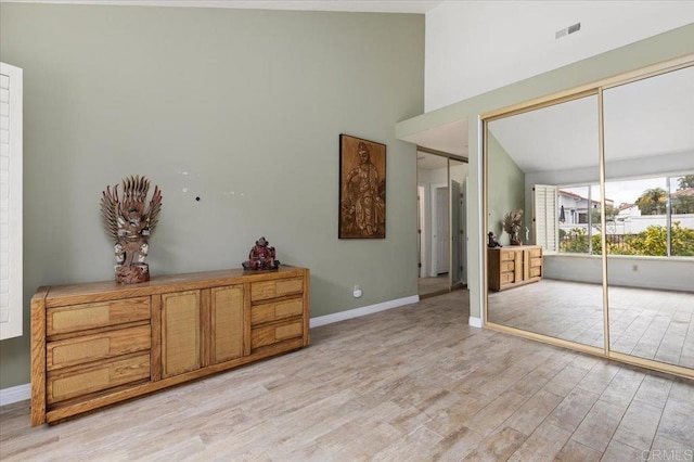 interior space featuring a towering ceiling and light hardwood / wood-style floors