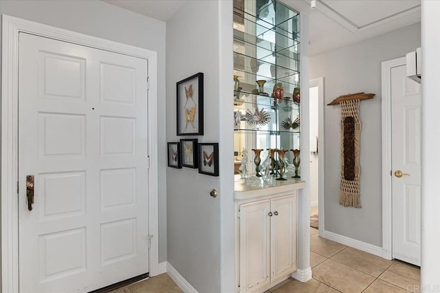 bar featuring white cabinetry and light tile patterned floors