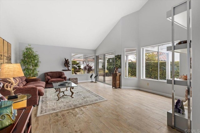 living room with high vaulted ceiling and light wood-type flooring