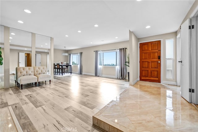 foyer with recessed lighting, light wood-style floors, and baseboards
