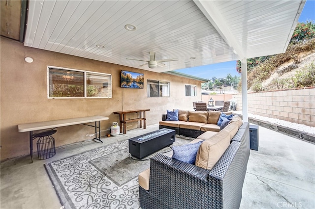 view of patio featuring an outdoor living space with a fire pit, ceiling fan, and fence