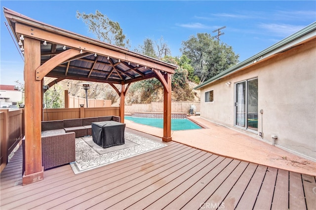 deck featuring a fenced in pool, a gazebo, a fenced backyard, and an outdoor hangout area