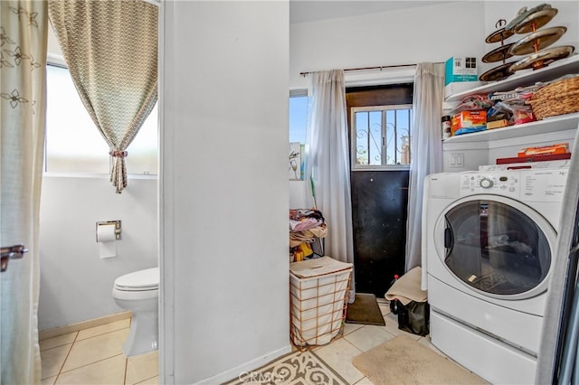 washroom featuring washer / clothes dryer, tile patterned floors, laundry area, and baseboards