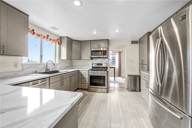 kitchen featuring a sink, gray cabinets, appliances with stainless steel finishes, and visible vents