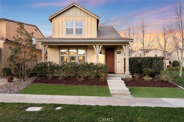 view of front of property featuring a porch and a lawn