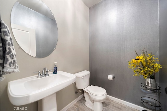 bathroom with sink, wood-type flooring, and toilet