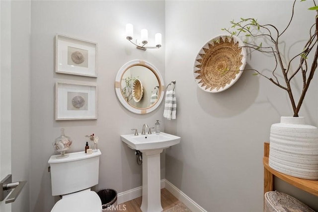 bathroom with hardwood / wood-style flooring and toilet