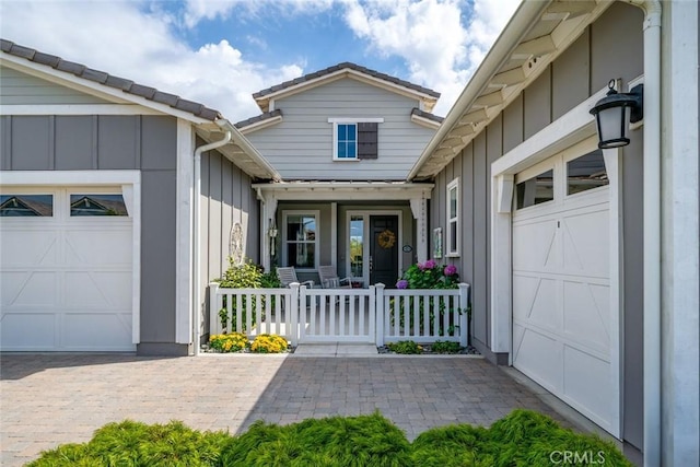 entrance to property featuring a porch and a garage