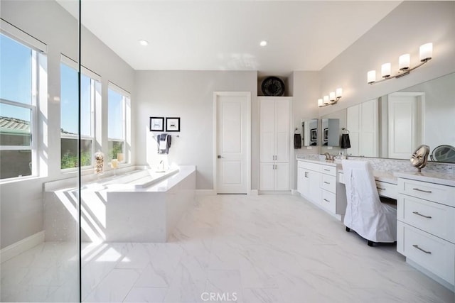 bathroom with vanity and a washtub