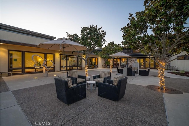 patio terrace at dusk featuring an outdoor living space