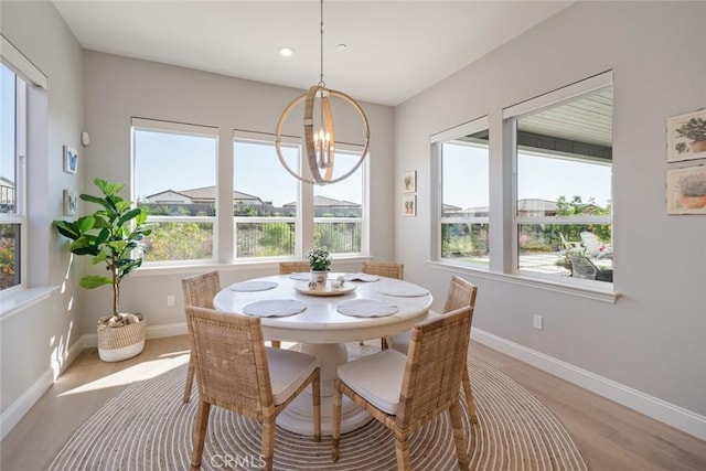 dining space featuring an inviting chandelier and light hardwood / wood-style flooring