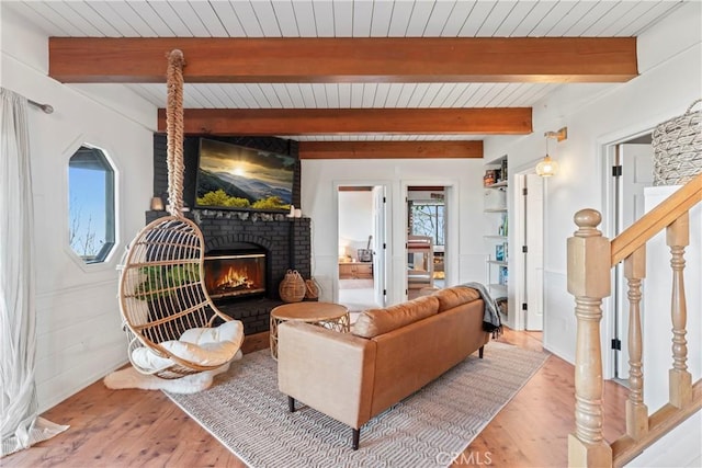 living area with a wealth of natural light, wood finished floors, a fireplace, and stairs